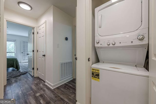 3203 Lenox Rd NE Unit 32, Atlanta, GA 30324 - washroom with estacked washer and dryer, dark wood-style flooring, and baseboards