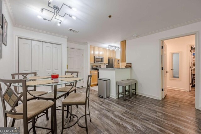 3203 Lenox Rd NE Unit 32, Atlanta, GA 30324 - dining area featuring crown molding, dark wood-type flooring, and baseboards