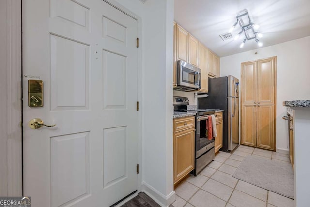 3203 Lenox Rd NE Unit 32, Atlanta, GA 30324 - kitchen with stainless steel appliances, light tile patterned floors, baseboards, and light stone counters