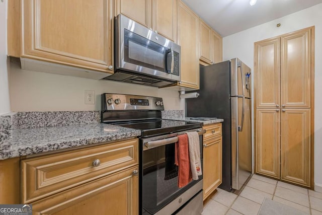 3203 Lenox Rd NE Unit 32, Atlanta, GA 30324 - kitchen featuring stainless steel appliances, light tile patterned floors, and light stone counters
