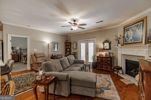 170 Elliot Cir, Watkinsville, GA 30677 - living area featuring dark wood-style flooring, a ceiling fan, a fireplace with raised hearth, crown molding, and french doors