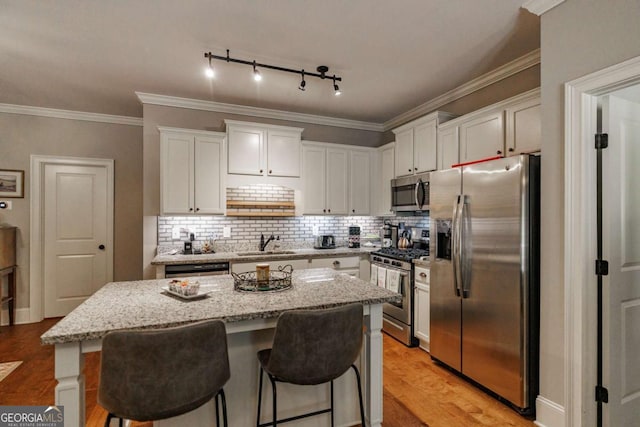 170 Elliot Cir, Watkinsville, GA 30677 - kitchen with stainless steel appliances, white cabinetry, light wood-style floors, a center island, and light stone counters