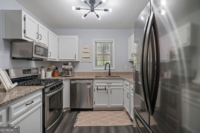 401 Berkeley Woods Dr, Duluth, GA 30096 - kitchen featuring stainless steel appliances, a chandelier, white cabinets, dark wood-type flooring, and light stone counters