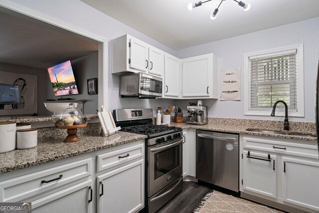 401 Berkeley Woods Dr, Duluth, GA 30096 - kitchen featuring appliances with stainless steel finishes, white cabinets, light stone countertops, and dark wood-style flooring