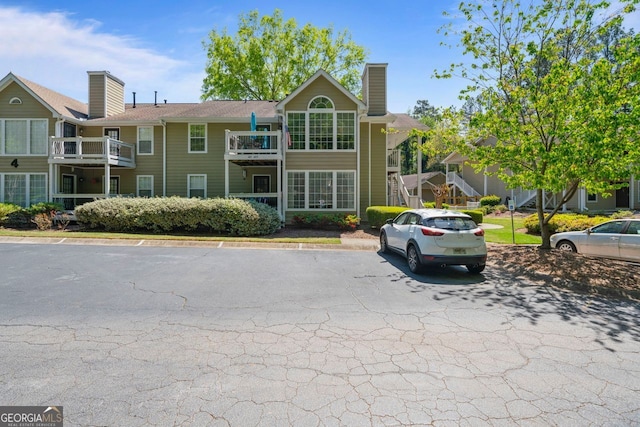 401 Berkeley Woods Dr, Duluth, GA 30096 - view of front of house featuring a chimney and uncovered parking