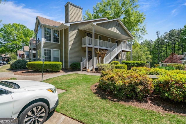 401 Berkeley Woods Dr, Duluth, GA 30096 - view of front of home featuring a chimney, stairs, a front yard, and a porch