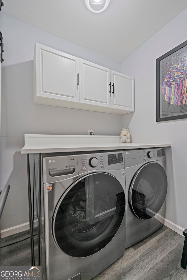401 Berkeley Woods Dr, Duluth, GA 30096 - washroom featuring washer and clothes dryer, cabinet space, and wood finished floors