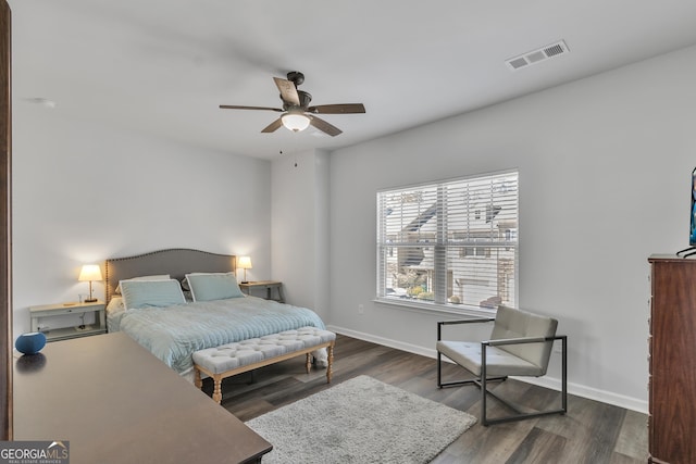 bedroom featuring ceiling fan, visible vents, baseboards, and wood finished floors