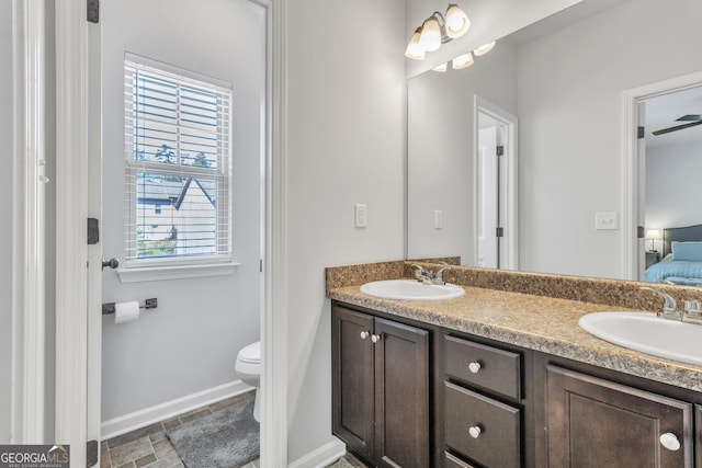 ensuite bathroom featuring ensuite bath, baseboards, a sink, and toilet