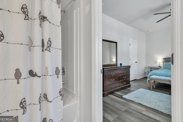 ensuite bathroom featuring shower / tub combo, vanity, baseboards, connected bathroom, and wood finished floors