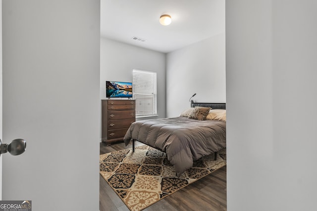 bedroom featuring wood finished floors and visible vents