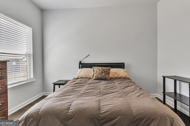 bedroom with dark wood-style floors and baseboards