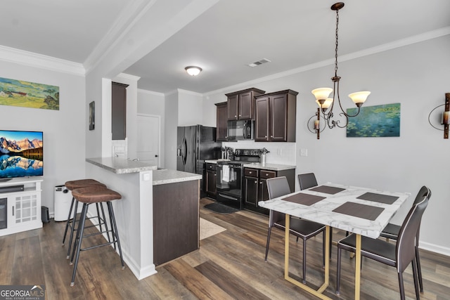 kitchen with dark brown cabinetry, an inviting chandelier, crown molding, decorative backsplash, and black appliances