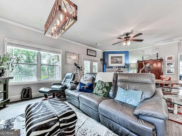 living room featuring crown molding, ceiling fan, visible vents, wood finished floors, and baseboards