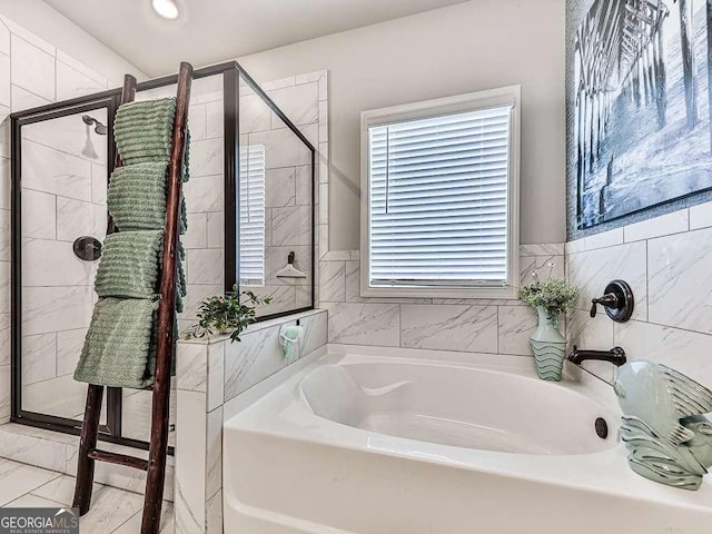 bathroom featuring a shower stall, a garden tub, and marble finish floor