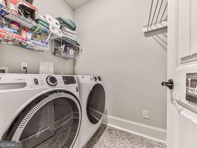 clothes washing area with washer and clothes dryer, laundry area, and baseboards
