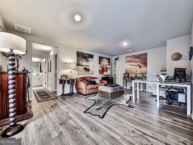 living area featuring visible vents, attic access, and wood finished floors