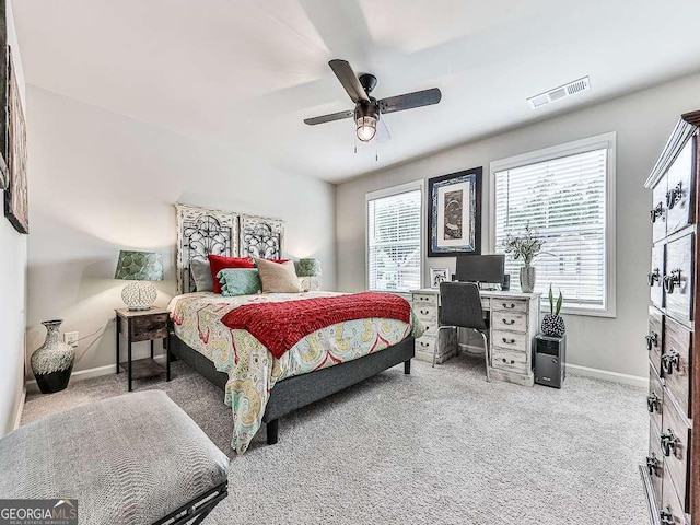 carpeted bedroom featuring baseboards, a ceiling fan, and visible vents