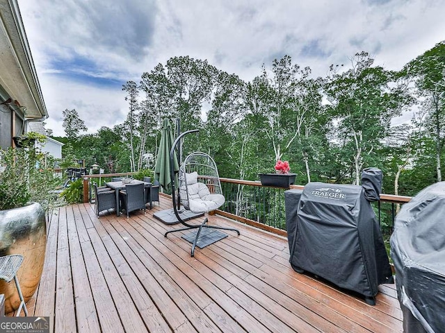 wooden terrace with grilling area and outdoor dining space