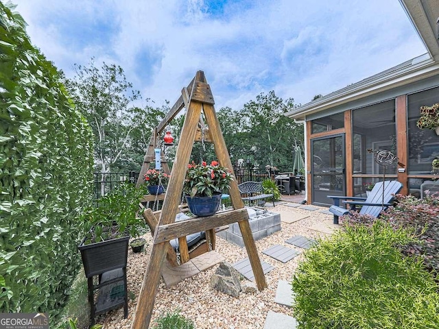 view of patio / terrace with fence and a sunroom