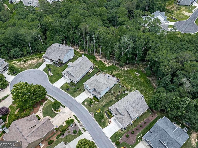 bird's eye view featuring a wooded view and a residential view