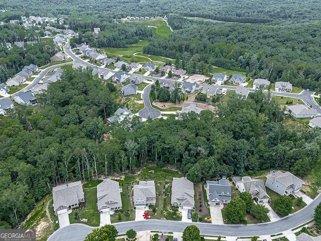 drone / aerial view with a wooded view and a residential view