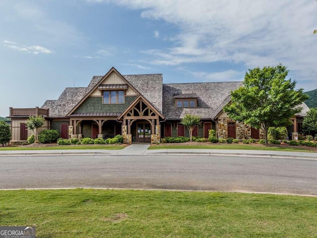view of front of house featuring stone siding and a front lawn