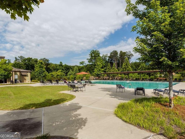 pool with a patio area and a yard