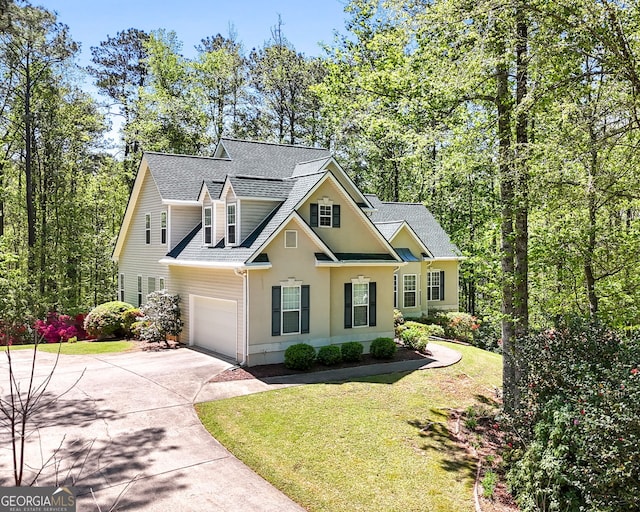 view of front of property with driveway, a front yard, a shingled roof, and a garage