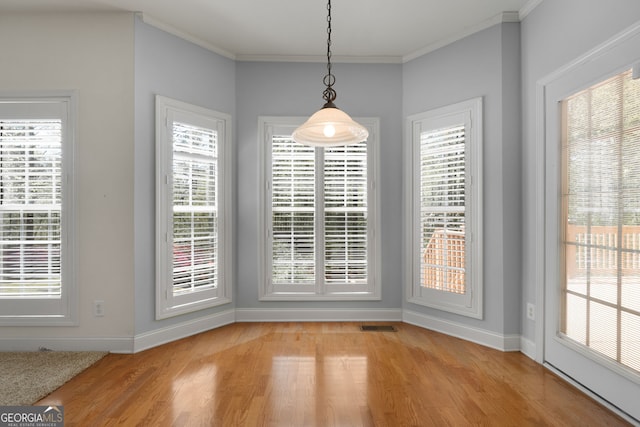 unfurnished dining area with crown molding, visible vents, baseboards, and light wood-type flooring