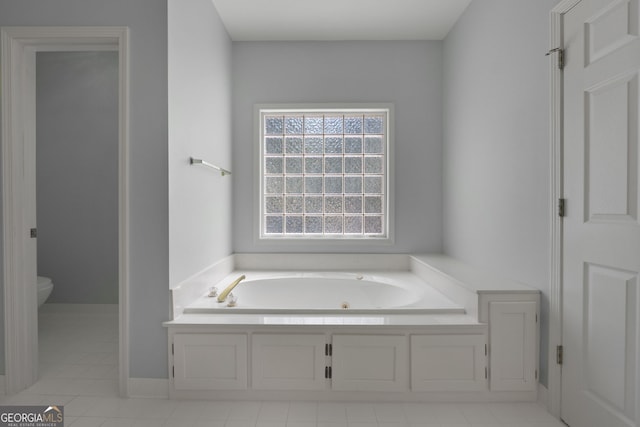 bathroom with tile patterned floors, toilet, and a garden tub