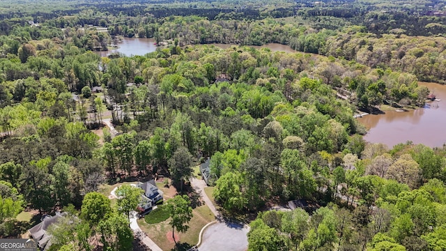 birds eye view of property featuring a water view and a view of trees