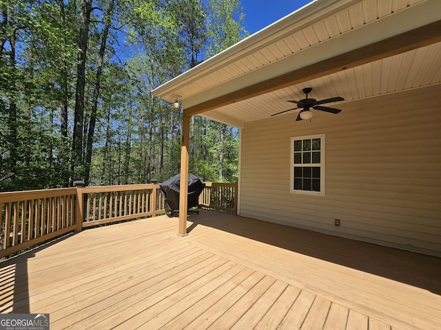 deck with area for grilling and a ceiling fan