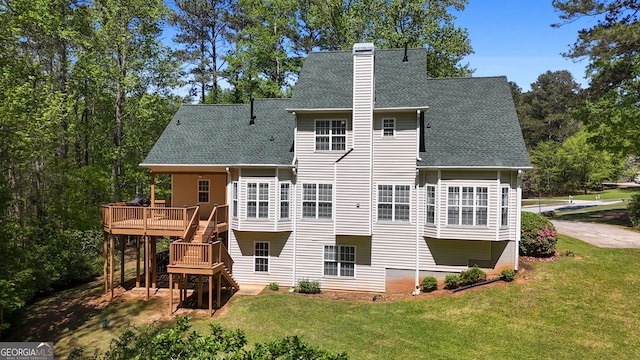 rear view of property with stairs, a wooden deck, a chimney, a shingled roof, and a lawn