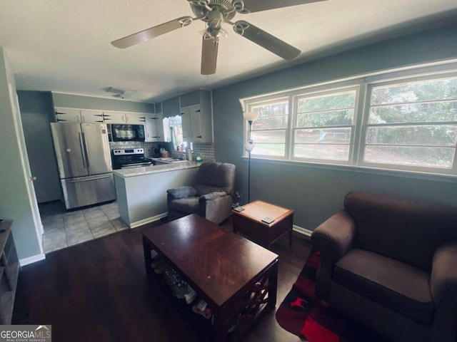 living room featuring light tile patterned floors, baseboards, and a ceiling fan