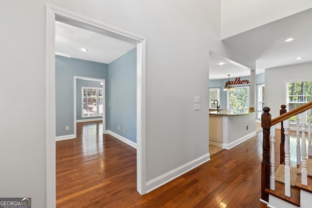 unfurnished dining area featuring an inviting chandelier, a raised ceiling, visible vents, crown molding, and hardwood / wood-style flooring