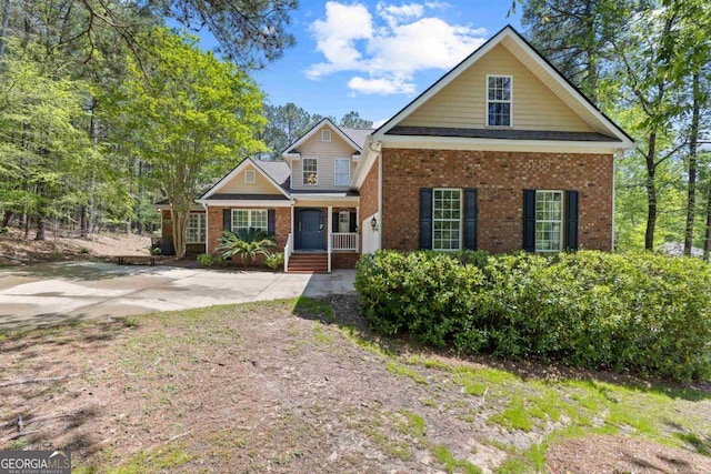 back of property with brick siding, roof with shingles, and a patio