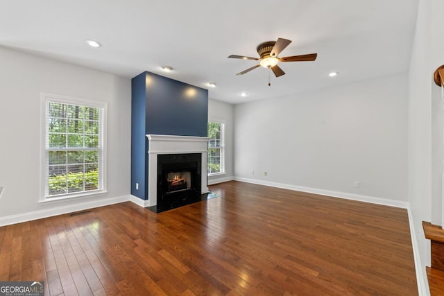 unfurnished living room with stairway, ceiling fan, baseboards, dark wood-style flooring, and recessed lighting