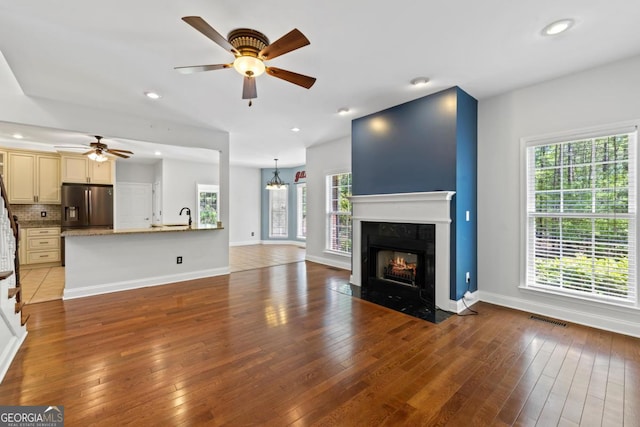 stairs with hardwood / wood-style floors, baseboards, a ceiling fan, and visible vents