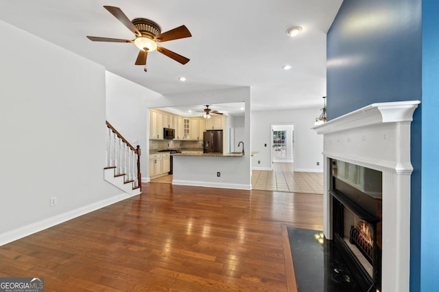 empty room with dark wood-type flooring, a raised ceiling, crown molding, and ceiling fan