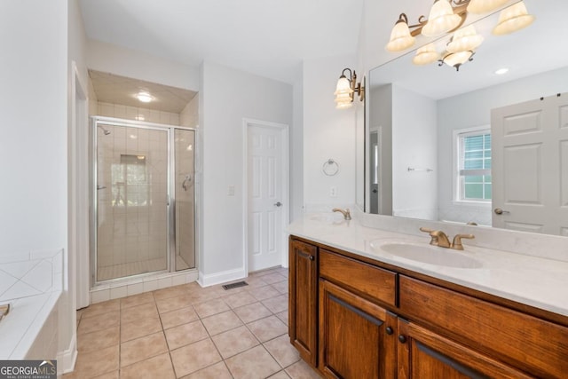 full bath featuring a sink, double vanity, a stall shower, tile patterned flooring, and ceiling fan