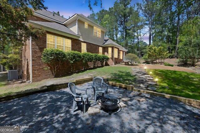 view of front of house with brick siding, a patio, and a front yard
