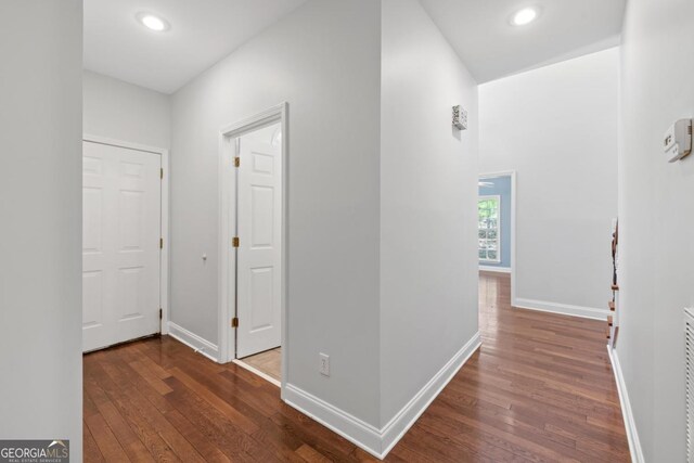corridor featuring attic access, baseboards, and light carpet