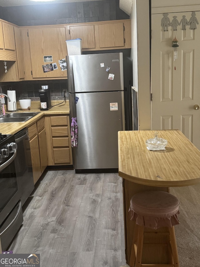 6183 Field Stone Dr, Douglasville, GA 30134 - kitchen featuring light wood-type flooring, decorative backsplash, stainless steel appliances, and a sink