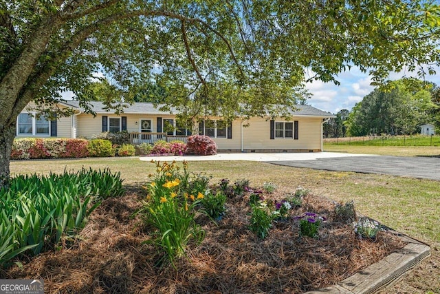 ranch-style house featuring a front lawn and driveway