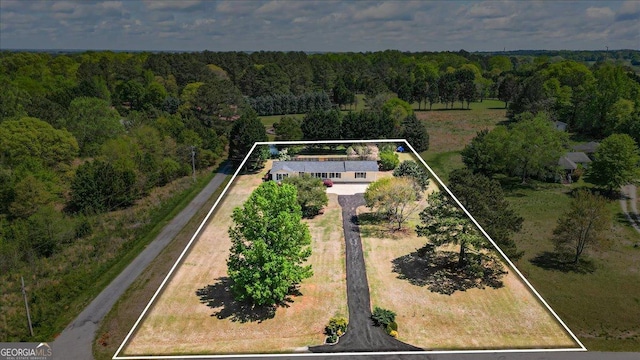 birds eye view of property featuring a forest view