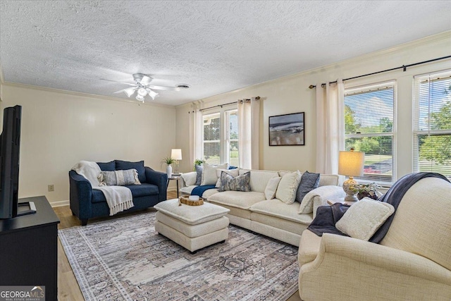 living area with ornamental molding, a wealth of natural light, and wood finished floors