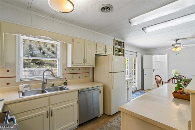 kitchen featuring visible vents, dishwasher, a sink, light countertops, and freestanding refrigerator
