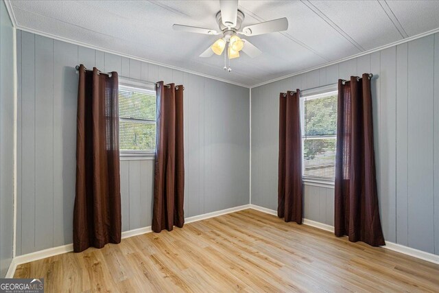 unfurnished room featuring crown molding, wood finished floors, and a healthy amount of sunlight