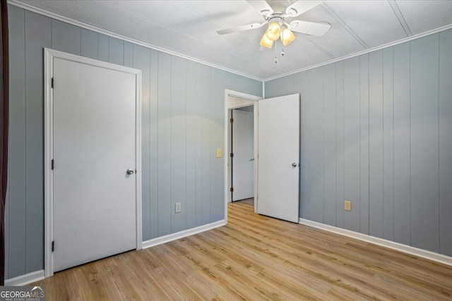 unfurnished bedroom with baseboards, crown molding, a ceiling fan, and wood finished floors